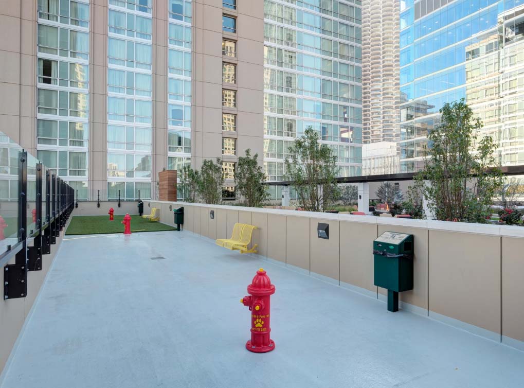 Outdoor dog park at urban high-rise apartment with fire hydrant and concrete surface built by Dog-ON-It-Parks